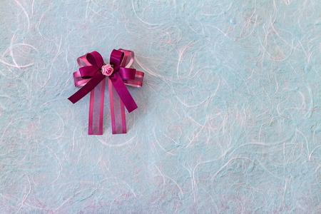 Purple bow with fabric flower on blue mulberry paper