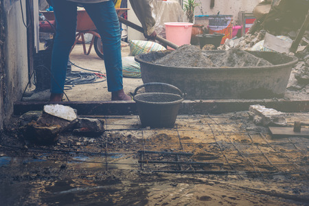 Worker mix cement with sand,pebble and water in big bucketの写真素材