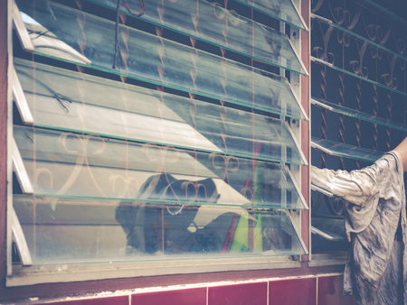 Female hand cleaning dirty window blind glassの写真素材