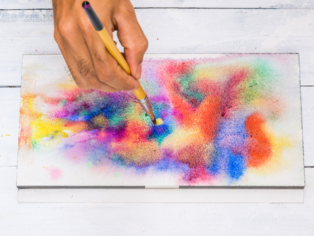 Closeup artist hand painting colorful water color on paperの写真素材