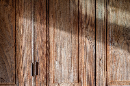 Closeup texture and background of old wooden door with sunlight and shadow use as backgroundの写真素材