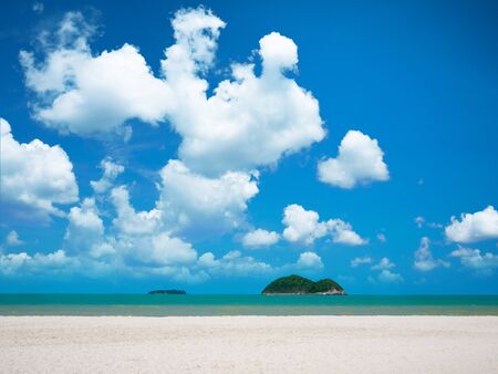 White sand beach with bright blue sky and cloud over sea with two island の写真素材
