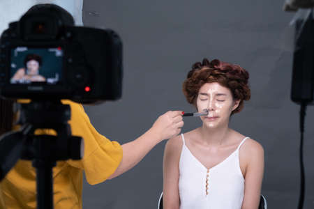 The makeup artist was doing the makeup for the model , Halloween concept