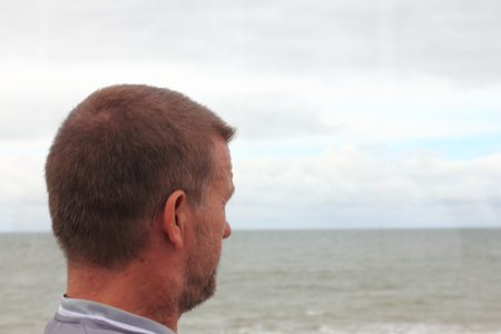 a man with short hair can look across the seaの写真素材