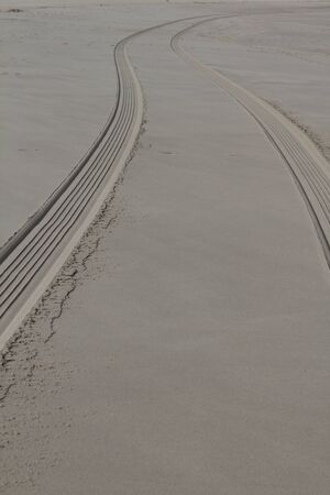 The fresh tire track of a vehicle in the wet sand