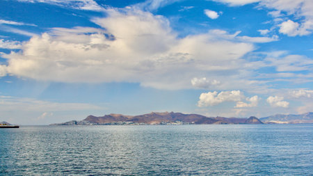 A rocky island juts out of the sea, while the blue sky can be seen in the background.