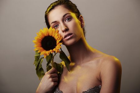 Beautiful woman with a sunflowerの写真素材