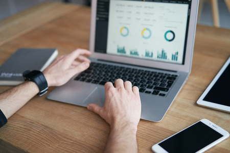 Closeup of man working on laptop with finances or ceo, graph, business analytics and strategyの写真素材