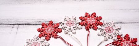 Red and white wooden snowflakes toys for Christmas tree on white wooden table backgroundの写真素材