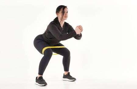 Young athletic woman making yoga and gymnastics stretching exercises isolated on white