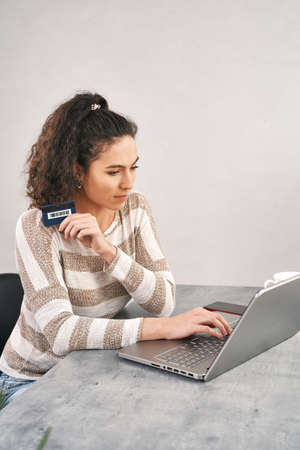 Happy woman holding credit card and using laptop for buying onlineの写真素材
