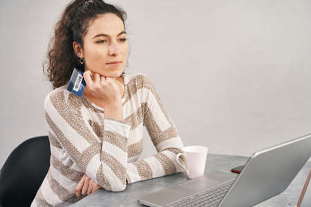 Happy woman holding credit card and using laptop for buying onlineの写真素材