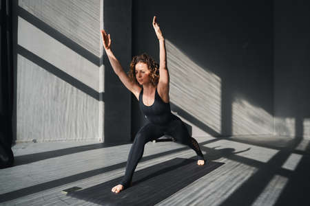 Young woman practicing yoga poses in an urban background on sunny dayの写真素材