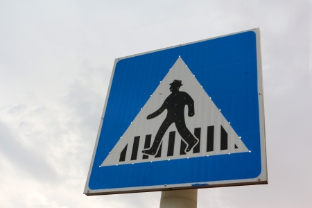 Zebra crossing blue and white sign from low angle pointの写真素材