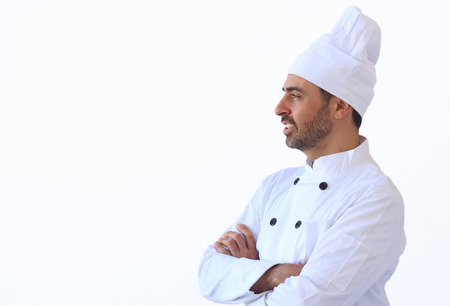 Bearded middle-aged chef in white toque and uniform standing looking at the copyspaceの写真素材