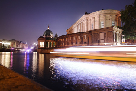 Lights of a passing boat on the spree river below the museum isle in Berlinのeditorial素材