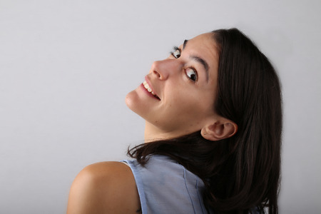 Attractive woman shot from her back leaning her head back toward the camera in a studioの写真素材