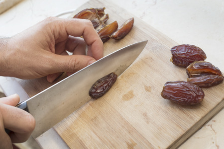 Cutting date with a chef's knife on a cutting board