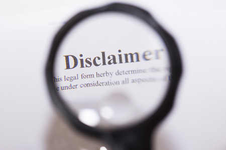 Disclaimer written on document through magnifying glassの写真素材
