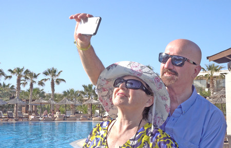 Couple taking a selfie at the pool on thier vacation