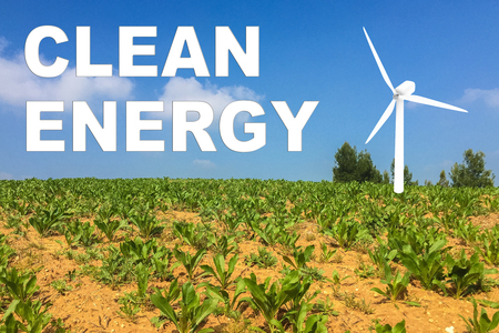 3D illustration of CLEAN ENERGY title on clear sky as a background, along with a wind turbine.の写真素材