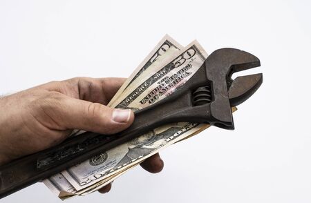 Technician with dirty hands holding wrench and USD bills in his hand Isolate over white backgroundの写真素材