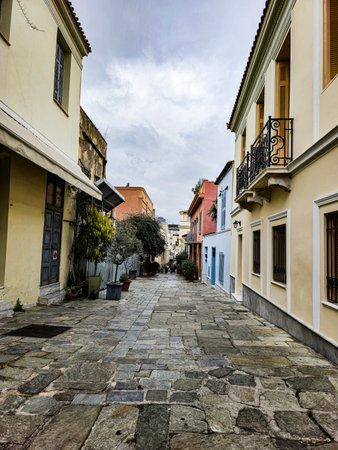 Cobblestone street in a historic neighborhood with colorful buildings and overcast skyの写真素材