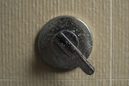 photo of a wet silver faucet in the bathroom