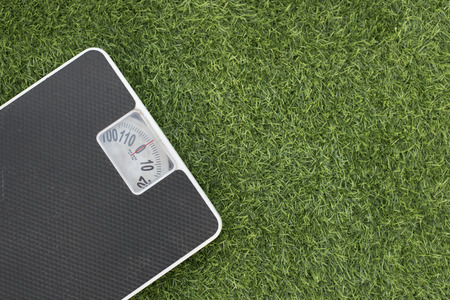 photo of weighing scale on a green grass.concept of weight loss and health fitnessの写真素材