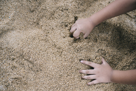 kid playing with sand.kid growth or development conceptの写真素材