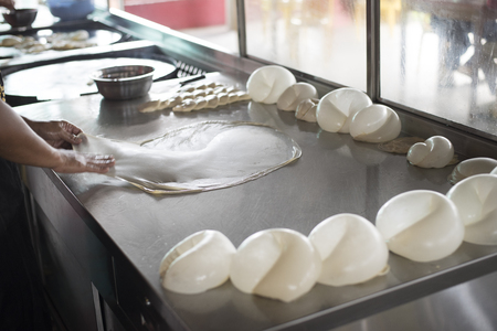 preparing,frying,cooking or making the malaysian flatbread,also known as roti canai.famous and popular in asia,especially malaysia.breakfast,lunch and dinner meal.famous food in malaysiaの写真素材
