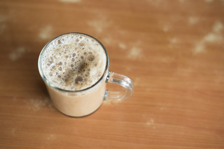 a glass of tea with milk on a table at mamak restaurant.famous or popular drink in malaysia.Malaysian favorite drink known as Teh Tarik.signature menu at mamak stall,cafe,restaurant or bistroの写真素材