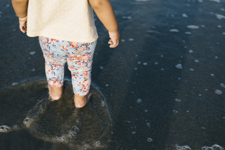 baby playing with waves on the beach.growth and learning concept.family and parenting conceptの写真素材