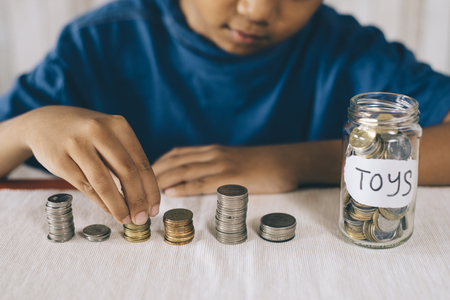 young boy counting his coins/savings to buy dream toys. Saving conceptの写真素材