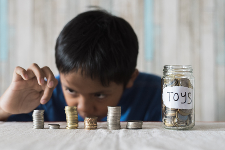 young boy counting his coins/savings to buy dream toys. Saving conceptの写真素材