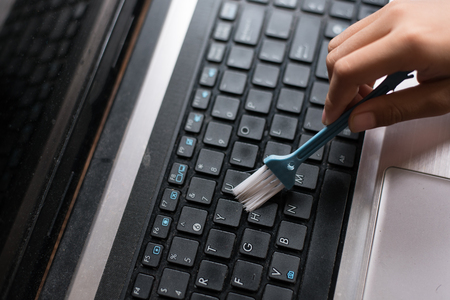 young boy cleaning laptop computer - clean up your computer dayの写真素材
