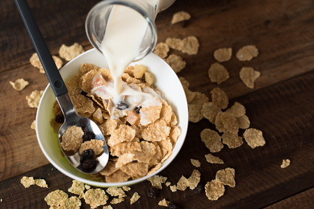 Pouring milk into breakfast cereal ( cornflakes ). healthy eating conceptの写真素材