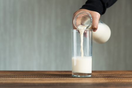 pouring milk into glass. filling a glass with milk.の写真素材