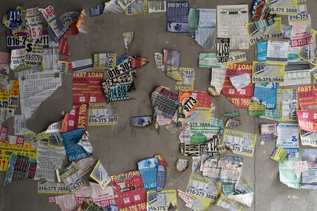 Kuala Lumpur, Malaysia - Illegal advertisement patched on wall. loan shark advert.のeditorial素材