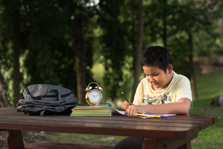 young asian boy having fun drawing at park in the evening sunny day.の写真素材