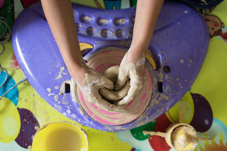 children hand playing with clay to make potteryの写真素材