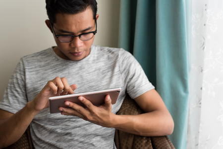 asian teen using digital tablet at home. social lifestyle conceptの写真素材