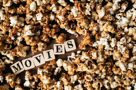 fresh popcorn background with MOVIES word on a wooden tableの写真素材