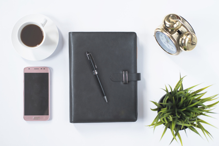 notebook,phone,clock and coffee on white flat lay. journalist workspace conceptの写真素材