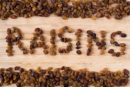 pile of raisins arranged to make RAISINS word. healthy food conceptの写真素材