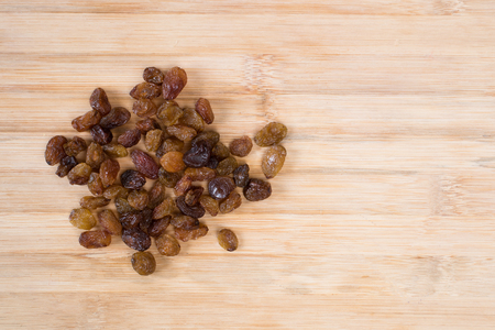 pile of dried raisins on a wooden board. healthy food conceptの写真素材