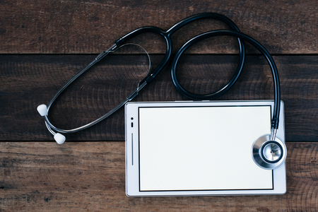 Stethoscope and digital tablet on wooden table background. medical health conceptの写真素材