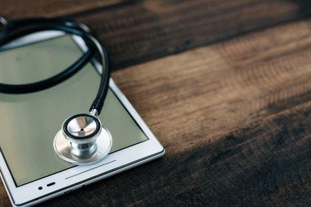 Stethoscope and digital tablet on wooden table background. medical health conceptの写真素材