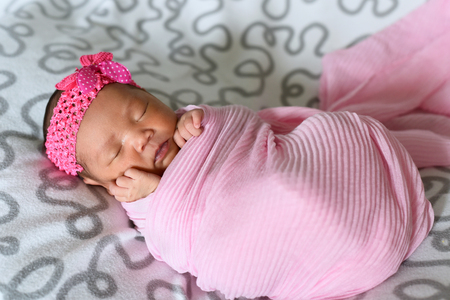 asian newborn baby sleepin in pink cloth wearing headband. newborn and motherhood conceptの写真素材