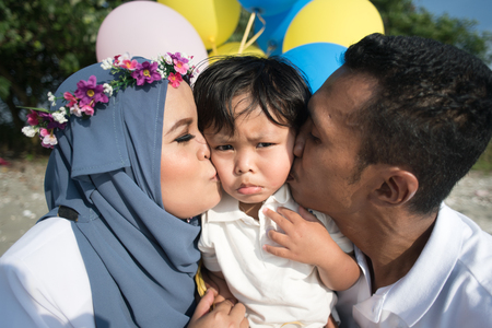 Asian family mother and father kissing their son. family conceptの写真素材